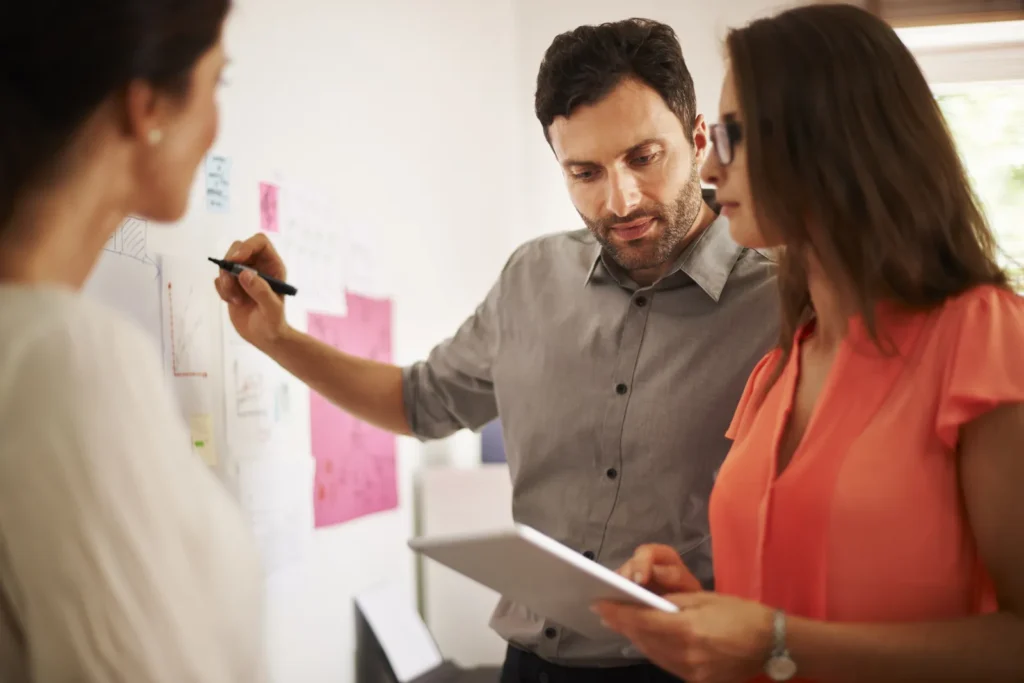 A team brainstorming ideas using sticky notes and a tablet
