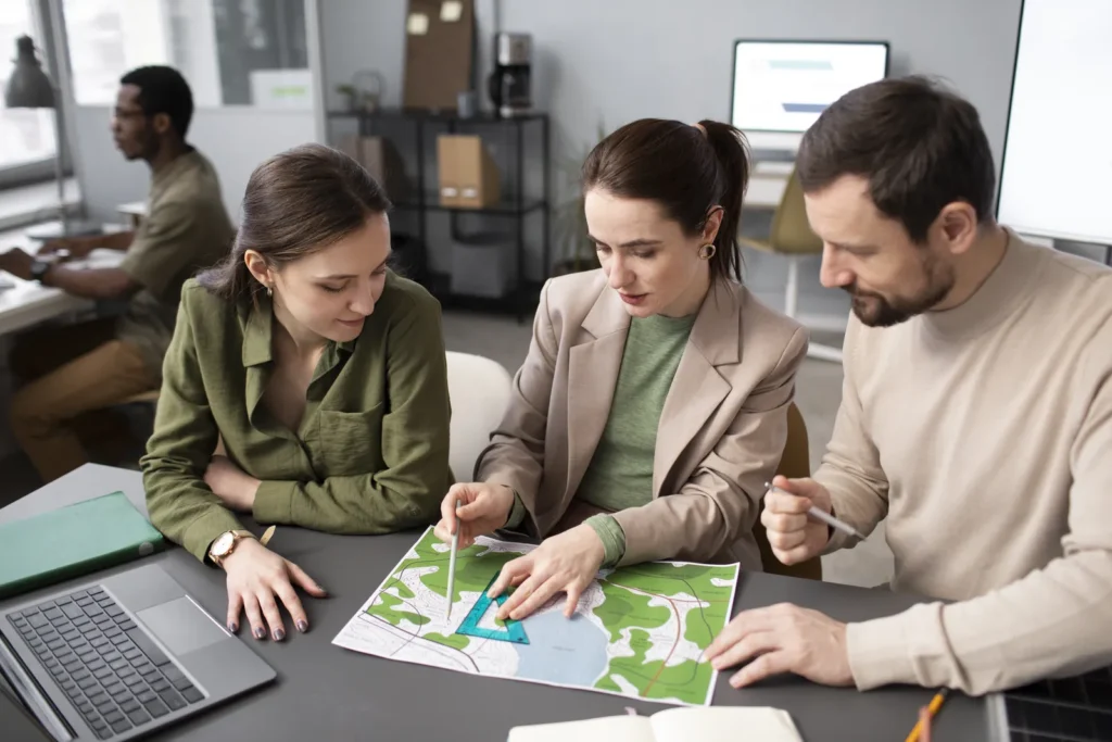 Equipo de tres personas revisando un plano con criterios de sostenibilidad